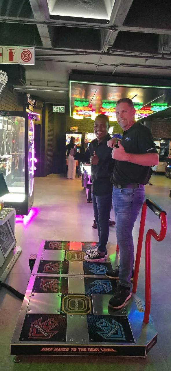 Two SelfieBox team members on the arcade dance game