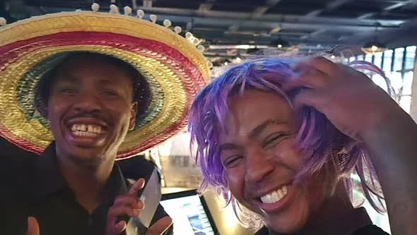 Gauteng team members smiling together in playful hats and a wig