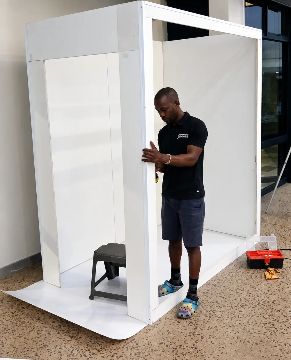 Attendant assembling the white magazine booth frame