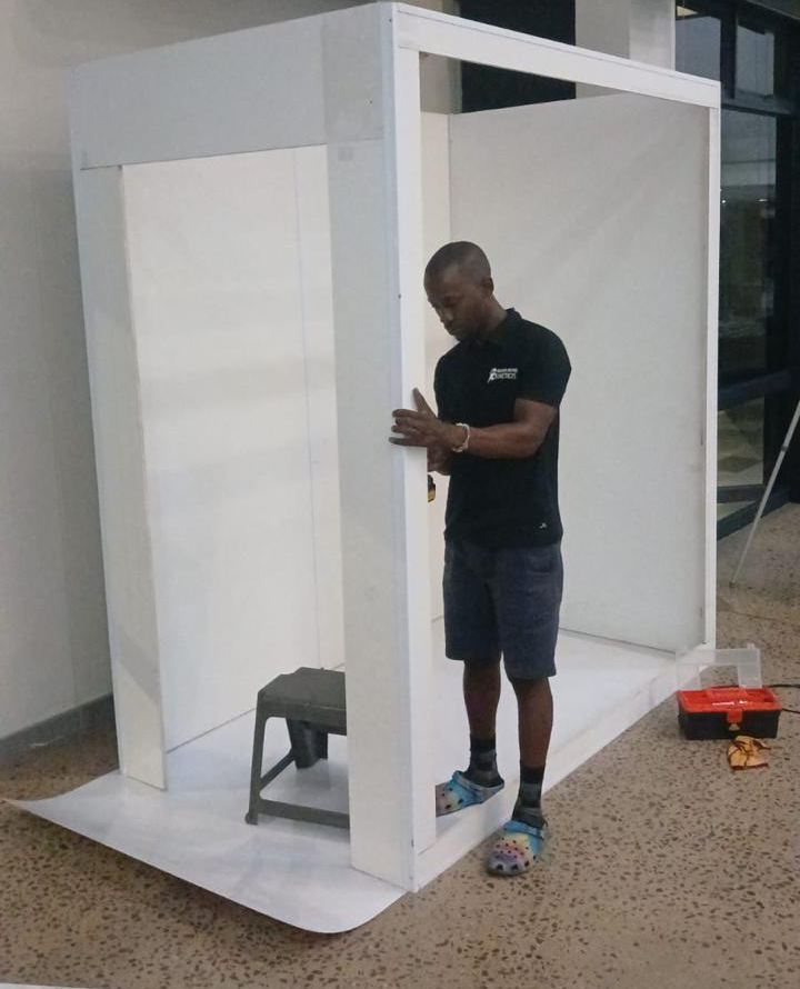 Attendant assembling the white magazine booth frame