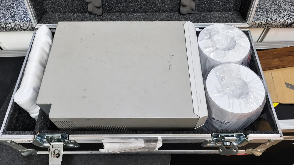 Printer and paper rolls protected inside a fitted transport case