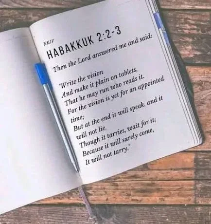 Open Bible showing Habakkuk 2 verses 2 to 3 about writing the vision