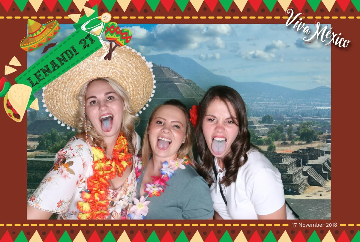 Wedding guests using sombreros and flower leis as traditional photo booth props