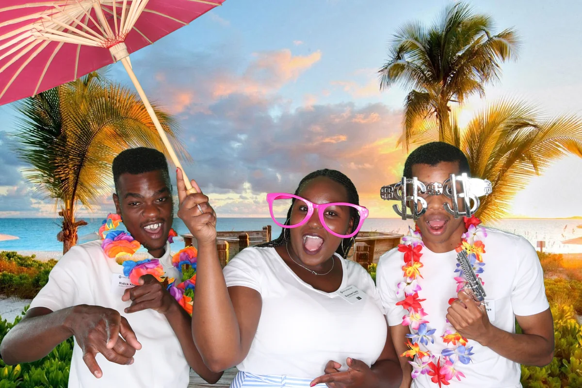 Wedding guests using oversized glasses, leis and novelty props in a photo booth