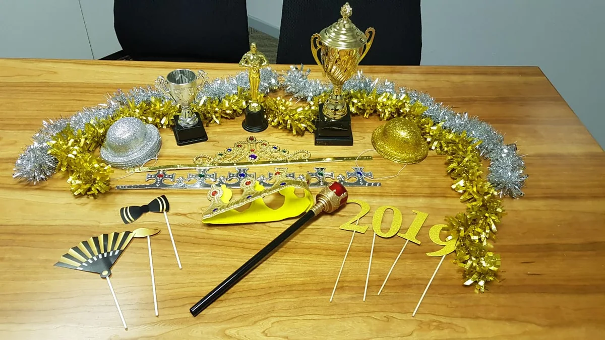 Awards night photo booth props including trophies, crowns and gold decorations