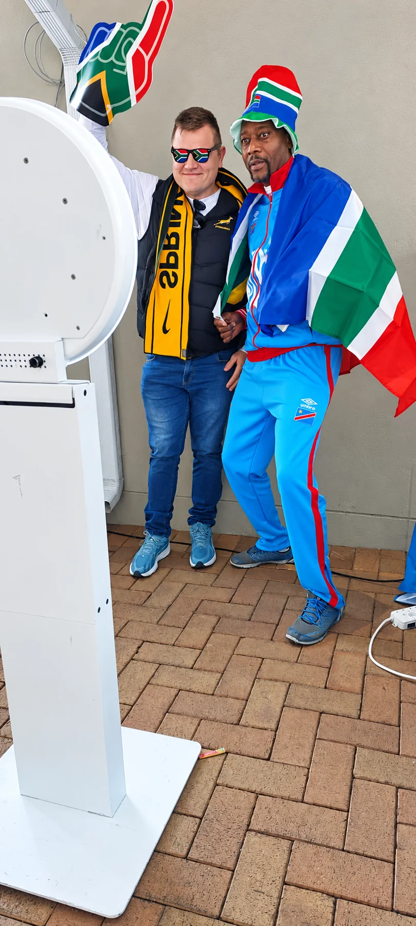 Two guests in South African colours posing beside a HaloBox photo booth