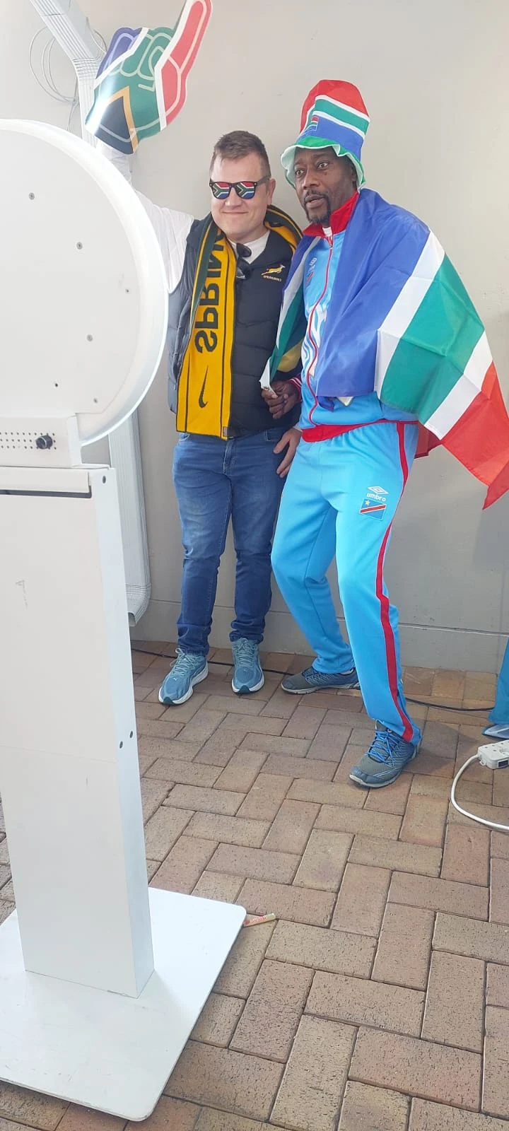 Two guests in South African colours posing beside a HaloBox photo booth