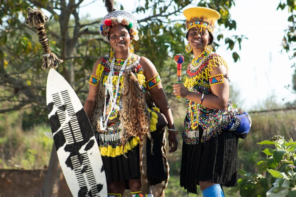 Two women smiling in colourful traditional Zulu attire in KwaZulu-Natal