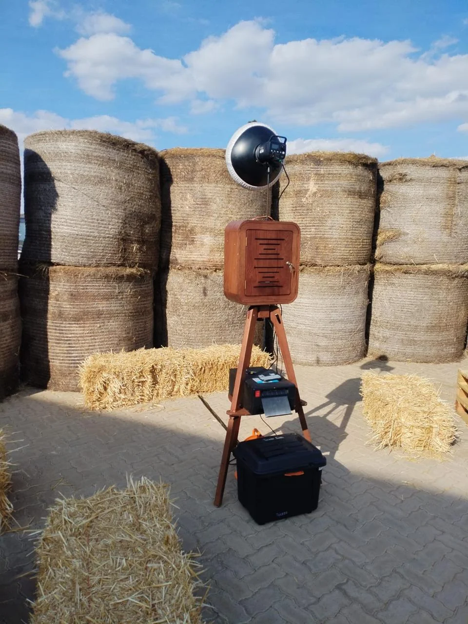 Wooden Retro photo booth setup with a rustic hay bale backdrop