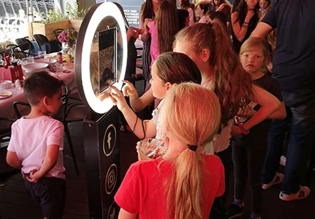 A group of guests gathered around and using a HaloBox at a busy event