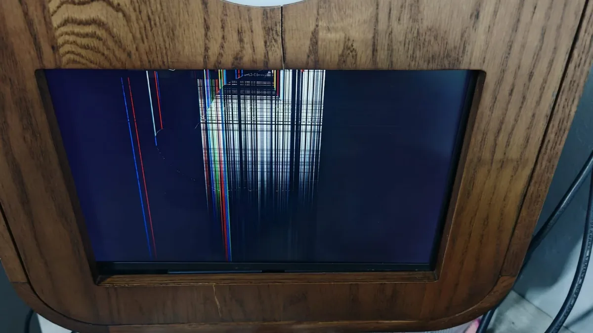 A damaged photo booth display with lines across the screen.