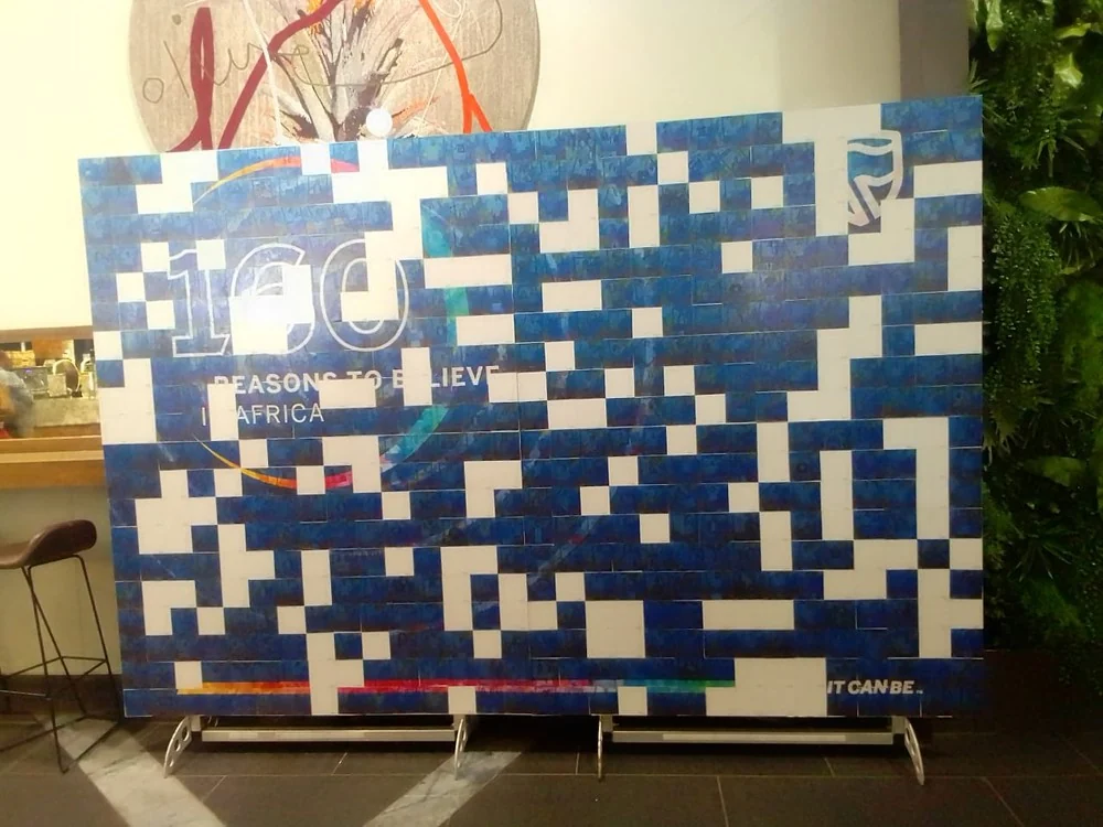 Mosaic — guest placing a photo on the mosaic wall